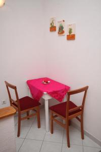 a table with two chairs and a pink cloth on it at Studio Brela 2713d in Brela
