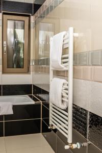 uma casa de banho com um toalheiro e um lavatório em Sasu Apartment em Timisoara