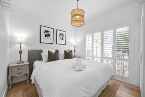 a white bedroom with a white bed and a window at Capella Villa No. 2 - luxury with outdoor kitchen in Blairgowrie
