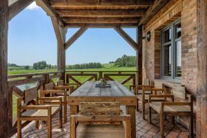 - patio z drewnianym stołem i krzesłami w obiekcie Mazurskie Wille w mieście Bogacko