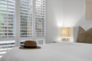 un sombrero sentado encima de una cama en un dormitorio en Capella Villa No. 3 - Luxurious beachside style, en Blairgowrie