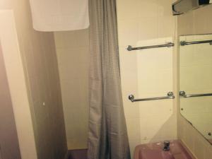 a bathroom with a shower curtain and a sink at Peek-a-Booze - Budget Hotel - Adults Only in Blackpool