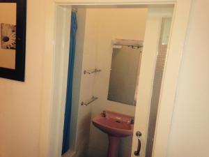 ein Bad mit einem Waschbecken und einem Spiegel in der Unterkunft Peek-a-Booze - Budget Hotel - Adults Only in Blackpool