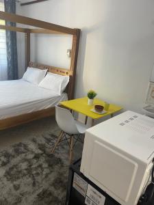 Dormitorio pequeño con cama y mesa amarilla en Urban studios, en Kilifi