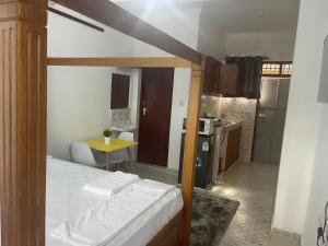 Un dormitorio con una cama y una mesa y una cocina. en Urban studios, en Kilifi