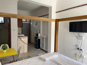 Un dormitorio con una cama y un televisor en una pared. en Urban studios, en Kilifi