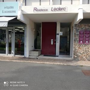 una tienda frente con una puerta roja en una calle en Le Clair centre ville, en Langon