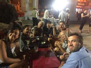 un grupo de personas sentadas alrededor de una mesa en The Imperfect Downtown Hoi An, en Hoi An