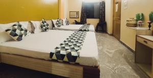 a bedroom with a large bed with black and white pillows at Maruti Group of Hotels - Shree Ram Darshan in Nāthdwāra