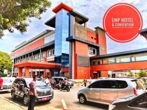 a building with cars parked in front of it at UNP Hotel & Convention in Padang