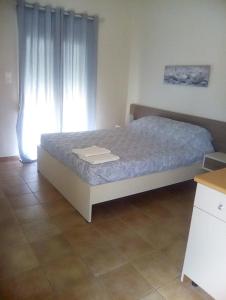 Schlafzimmer mit einem Bett und einem Fenster in der Unterkunft Malia Private Yard in Pírgos