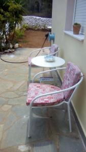 einen Tisch und zwei Stühle neben einem Gebäude in der Unterkunft Malia Private Yard in Pírgos