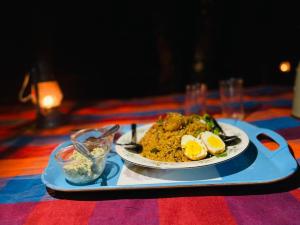 un plato de comida en una bandeja sobre una mesa en The Cliff Tea Glamping, en Badulla