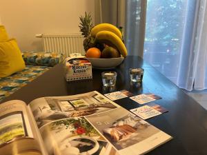 a table with a book and a bowl of fruit at Domki i Apartamenty Całoroczne Koliber in Władysławowo