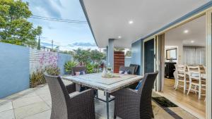 a dining room with a table and chairs on a patio at Coastal House in Gold Coast
