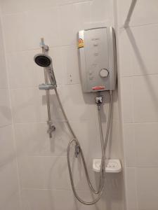 a shower with a hose attached to a wall at HAPPY SPACE วิลล่าทั้งหลัง 2นอน 2น้ำ ฟรี Wifi จอดรถ in Nakhon Phanom