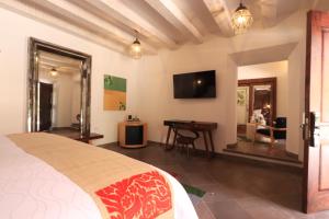 a bedroom with a bed and a desk and a television at Concepción Hotel Boutique - Adults Only in San Miguel de Allende