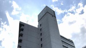 wysoki budynek z niebem w tle w obiekcie Men Only Capsule Room & Sauna, Bathhouse 男性専用サウナ&カプセル Minami Roppongi w Tokio