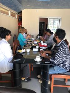 a group of people sitting at a table eating food at Hotel Lilyland Pvt Ltd in Pokhara