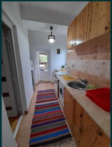 a kitchen with a sink and a washing machine at Casa Teonia in Tăşnad