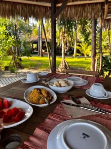 Amrita Maumere Resort في موميري: طاولة خشبية عليها صحون طعام
