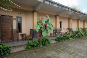 a house with chairs and tables and a plant at Pelangi Homestay Bedugul RedPartner in Bedugul
