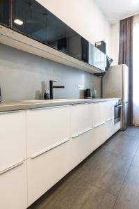 a kitchen with white cabinets and stainless steel appliances at Luxury Nova Home next to the New York Café in Budapest