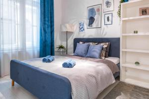 a bedroom with a blue bed with towels on it at Luxury Nova Home next to the New York Café in Budapest