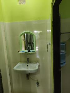a bathroom with a sink and a mirror at Kathmandu Resort in Havelock Island