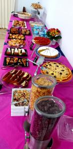 une longue table remplie de différents types de denrées alimentaires dans l'établissement Hotel Senza Pensieri Riccione, à Riccione