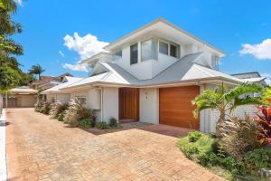 Casa blanca con entrada de ladrillo en Ocean Sapphire, en Byron Bay