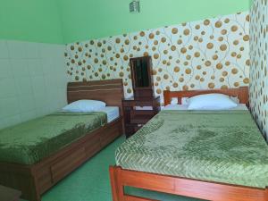 a room with two beds and a mirror at Omah 365 Homestay in Yogyakarta