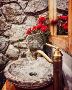 a bathroom sink with red flowers in a stone wall at House Arupium in Otočac