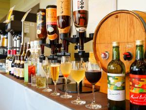 a bar with glasses of wine and wine bottles at Aso Resort Grandvrio Hotel in Aso