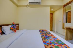 Un dormitorio con una cama con una manta de colores. en FabHotel Crystal Homes en Pune