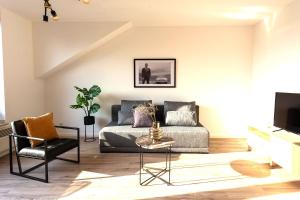 a living room with a couch and a chair at Cozy 4 room apartment in Hilden in Hilden