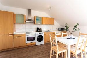 a kitchen with wooden cabinets and a table with chairs at Cozy 4 room apartment in Hilden in Hilden
