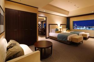 a hotel room with two beds and a couch at ANA Crowne Plaza Okayama, an IHG Hotel in Okayama