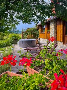 a garden with red flowers in front of a house at House Arupium in Otočac