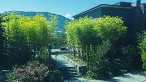 eine Treppe mit Bäumen, einem Zaun und einem Gebäude in der Unterkunft Hakone Gora KARAKU in Hakone