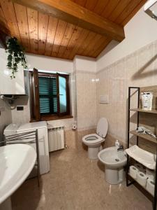 a bathroom with two sinks and a toilet and a window at Casa Nico in Montemarciano