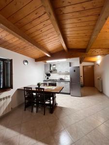 a kitchen with a wooden ceiling with a table and chairs at Casa Nico in Montemarciano