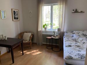 1 dormitorio con cama, mesa y ventana en Skogshemmet, en Ludvika