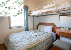 小松市Hyper Hotel Komatsu的一间带双层床和书桌的卧室
