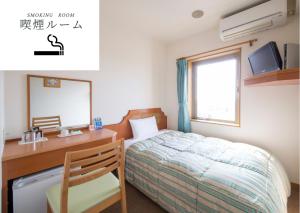 a bedroom with a bed and a desk and a window at Hyper Hotel Komatsu in Komatsu