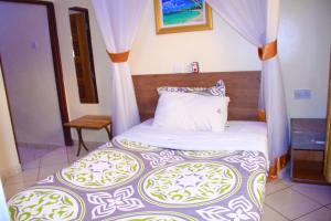 a bedroom with a bed with a canopy at Hoima Buffalo Hotel & Business Hub LTD in Hoima