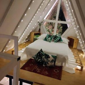 1 dormitorio con cama blanca y ventana en Chalet entrenubes en Medellín