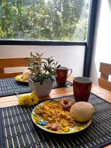 a table with a plate of food and two coffee cups at Chalet entrenubes in Medellín
