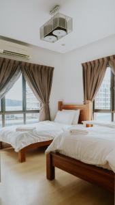 two beds in a room with large windows at Petronella Apartment C1 Marina Court in Kota Kinabalu
