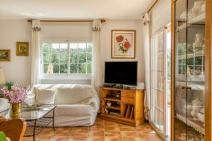 a living room with a couch and a television at Villa Casa Dolores Style Catalan in Begur